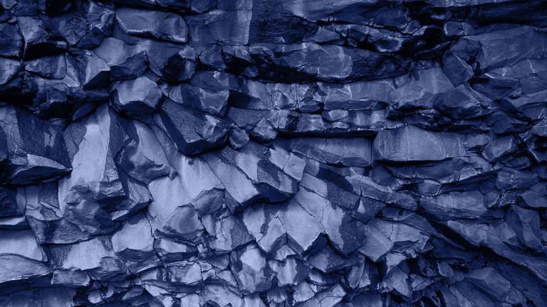 Texture de roche basaltique, symbolisant la solidité et la robustesse des investissements patrimoniaux.