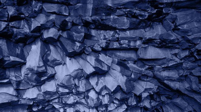 Texture de roche basaltique, symbolisant la solidité et la robustesse des investissements patrimoniaux.